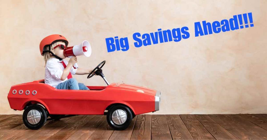 a boy in a play car with a microphone saying "big savings ahead!!!"