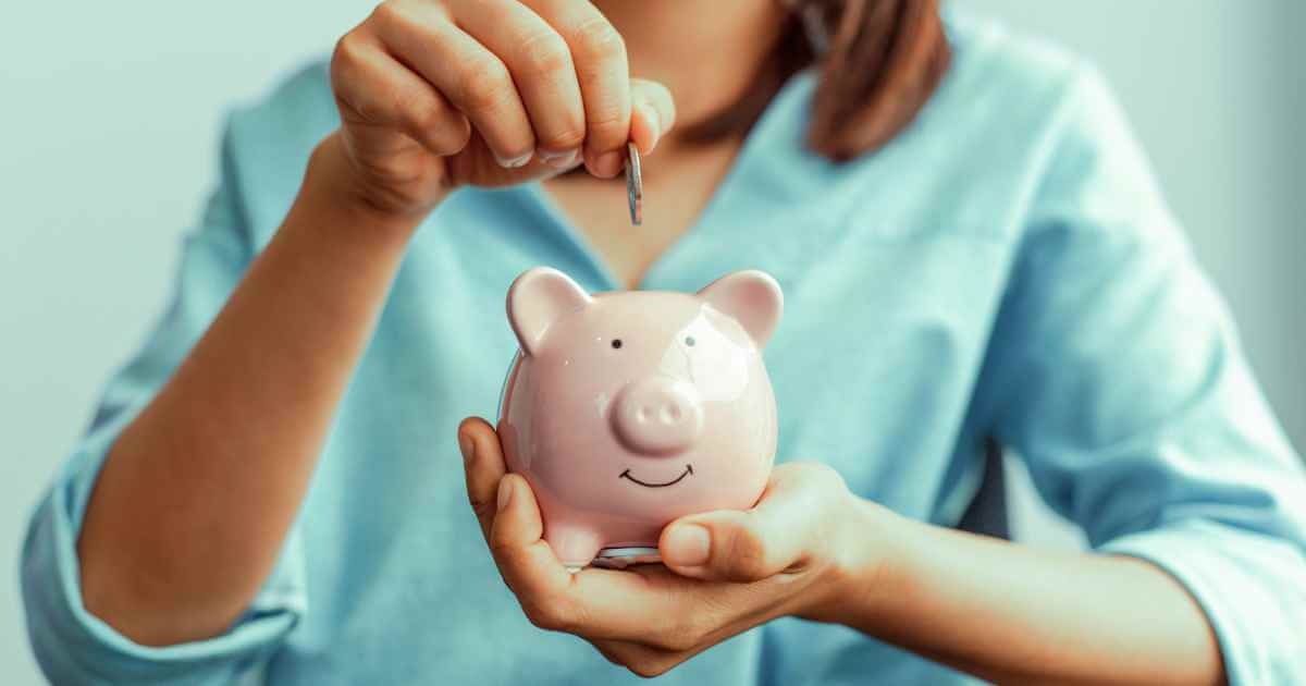 a woman putting a coin into a piggy bank showing how to save money on your car purchase