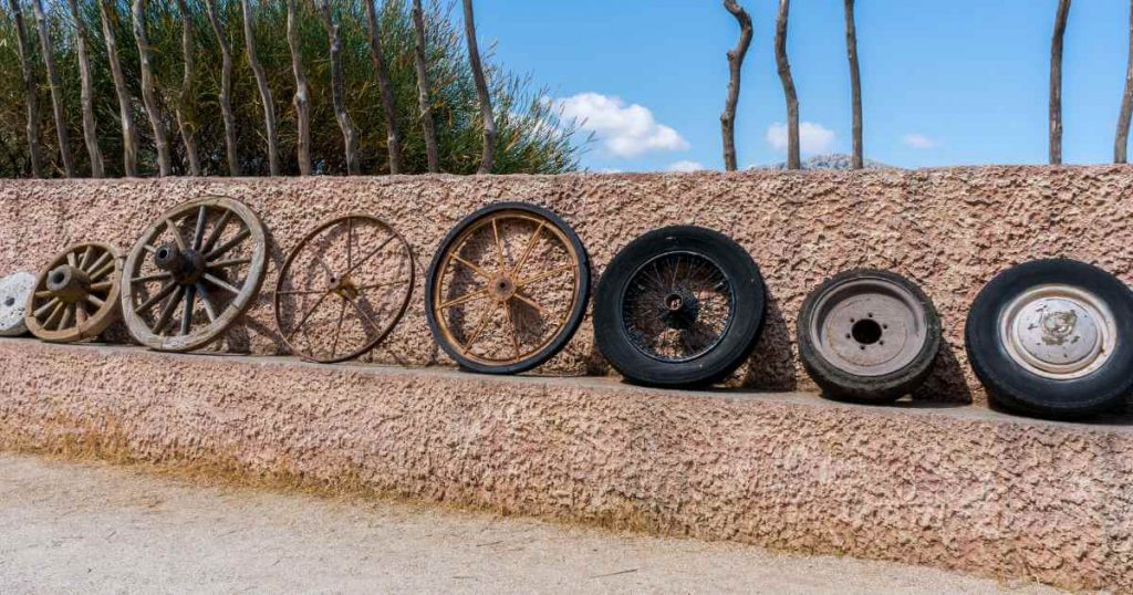 a row of wheels from a basic wood block to modern car wheels showing the evolution of in house financing car dealers