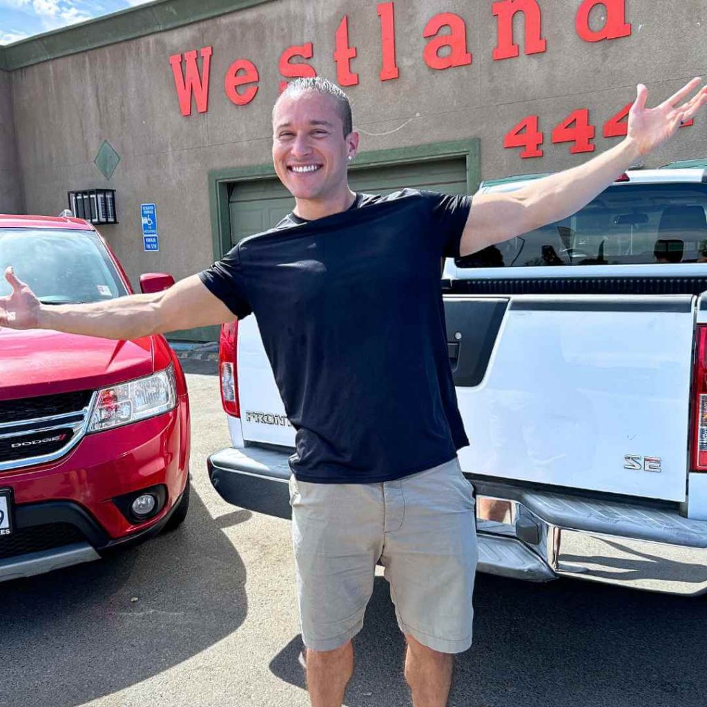 one of Westland Auto Sales Fresno's In House Financing Car Dealers' staff holding his arms wide to welcome everyone into the team