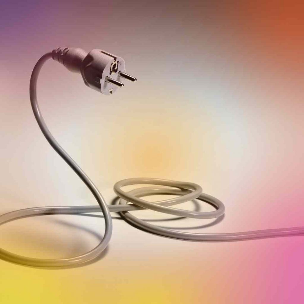 A Colorful picture of a plug and wire standing like a snake