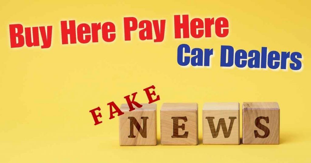wooden blocks that read 'fake news' and he words buy here pay here car dealers above them
