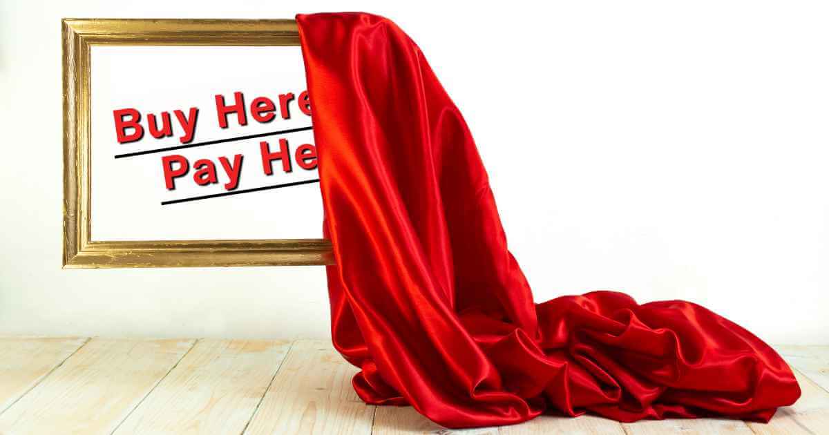 a bright red sheet being slipped off of a frame revealing the phrase "buy here pay here" inside of it