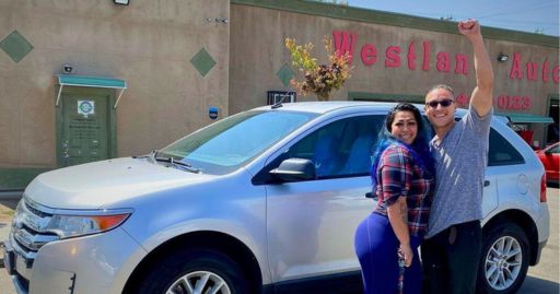 a man and woman overjoyed with the vehicle they chose to join Westland Auto Sales' buy here pay here program. 