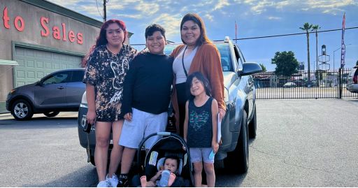 a happy member, a single mother of four, with all her children around her, excited about the results our buy here pay here in Sanger CA could provide her.