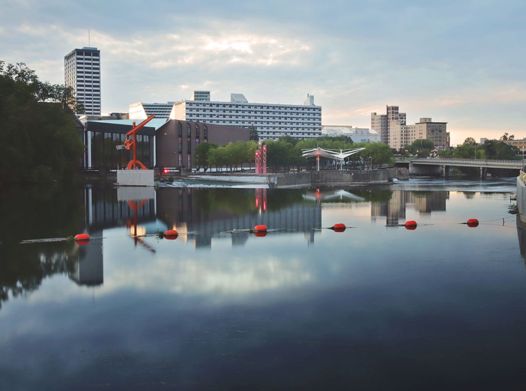 Downtown South Bend skyline with buildings reflecting on the St. Joseph River.