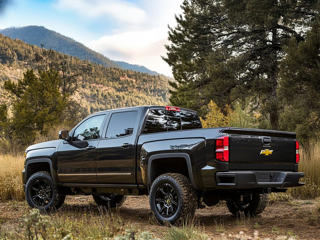 Black Chevy Silverado pickup truck parked outdoors in the mountains.