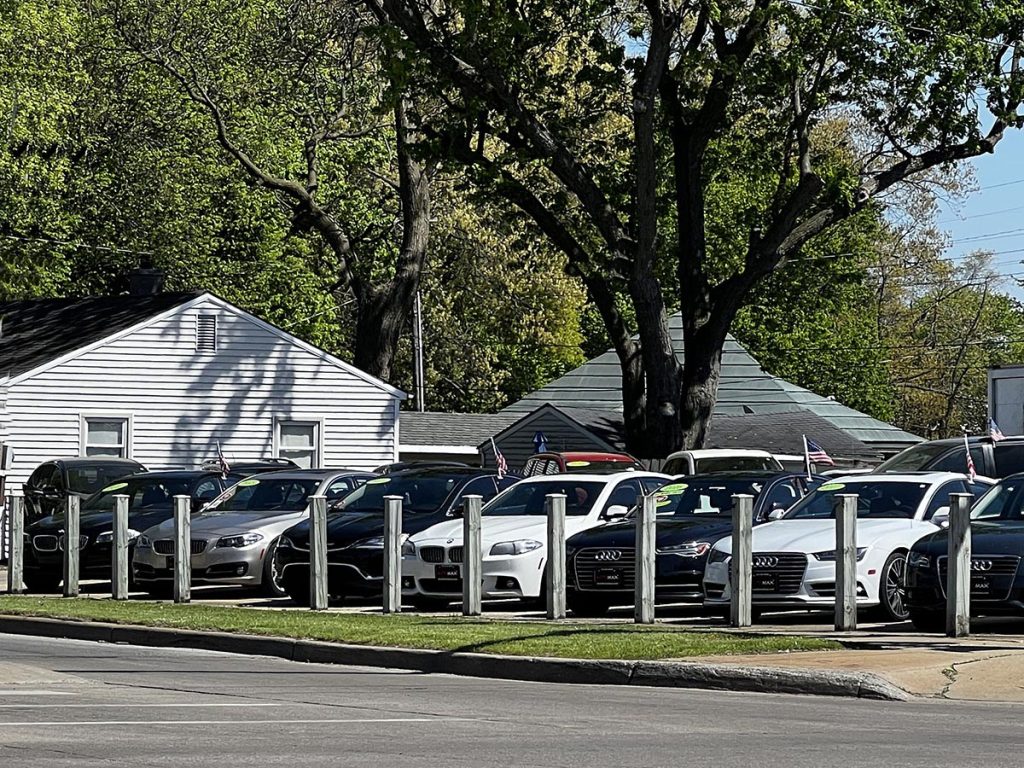 Row of used cars under $10,000 at Automax Indiana dealership lot in Mishawaka.