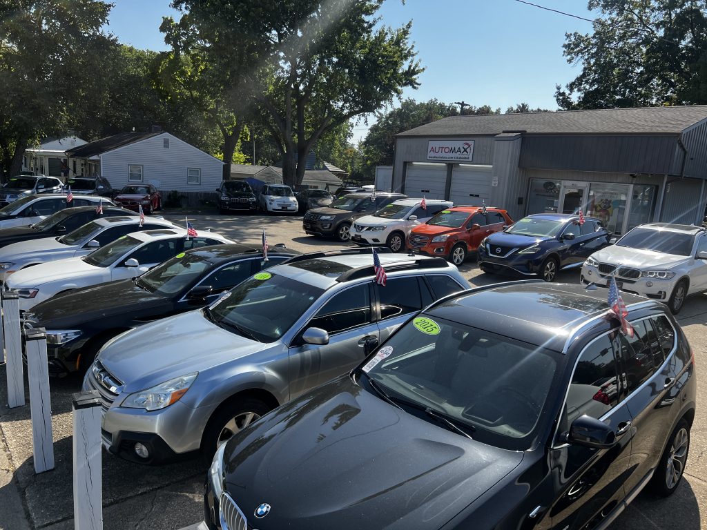 used cars for sale at Automax Indiana dealership lot in Mishawaka with BMW and Audi sedans displayed with pricing and year stickers