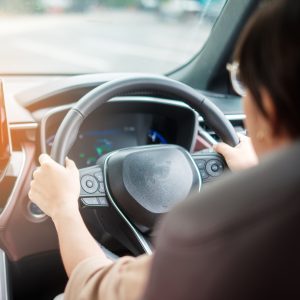 woman-driver-driving-a-car-on-the-road-hand-controlling-steering-wheel
